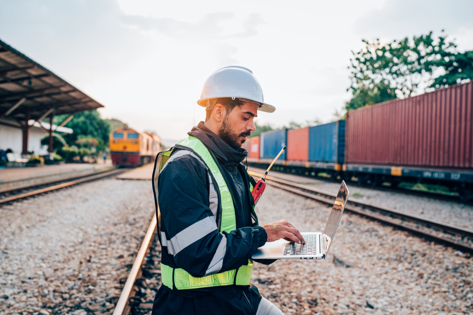 Wagenmeister mit Laptop vor einem Containerzug